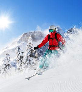 covek u crvenoj jakni skija