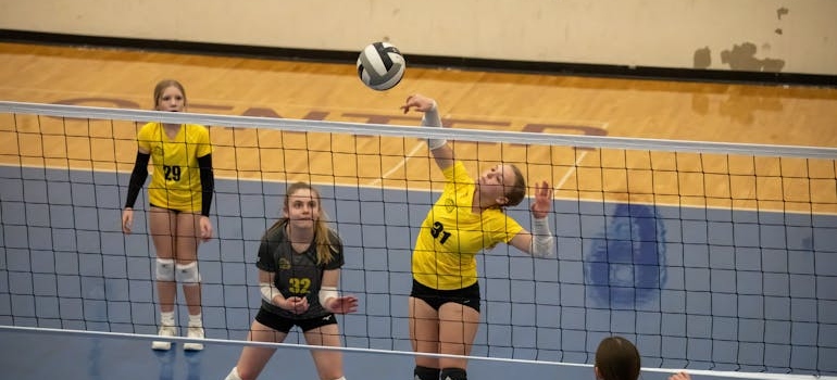 Devojčice igraju odbojkaški meč u dvorani