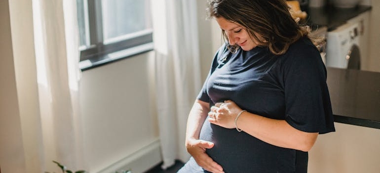 zena se drzi za stomak i pita se da li postoji putno osiguranje za trudnice
