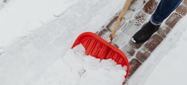 čovek čisti sneg lopatom zna koji su Saveti za bezbrižnu zimu