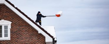 covek cisti sneg sa krova