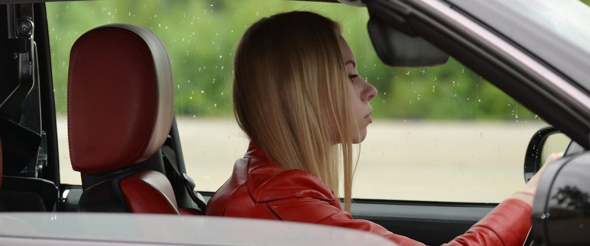 zena vozi crveno auto