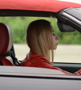 zena vozi crveno auto