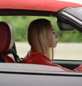 zena vozi crveno auto