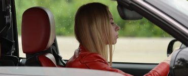 zena vozi crveno auto