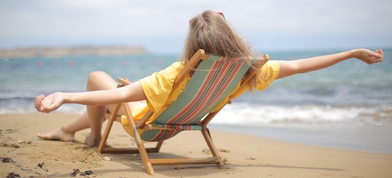 zena odmara na plaži tokom letovanja nakon pakovanja putne apoteka za letovanje